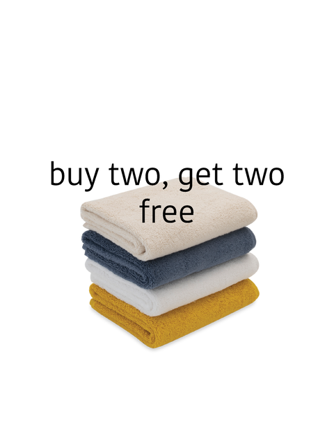 Stack of folded towels in beige, blue, white, and yellow with promotional text 'buy two, get two free' on a white background.