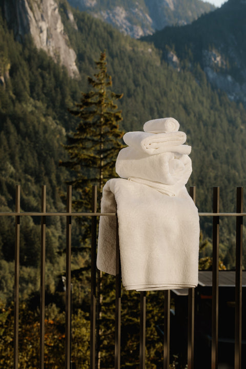 Organic and Fairtrade cotton towels folded on a fence overlooking the mountains
